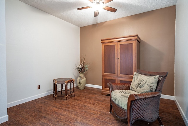 sitting room with dark hardwood / wood-style floors, ceiling fan, and a textured ceiling