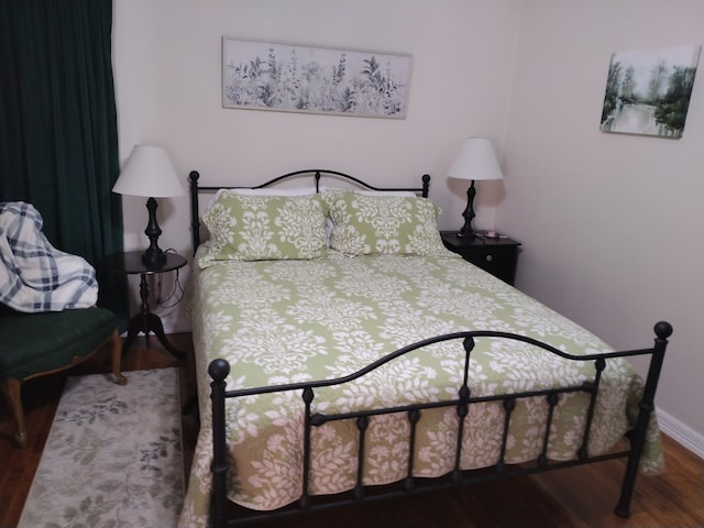 bedroom with dark wood-type flooring