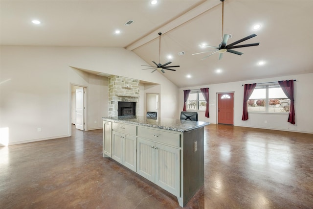 kitchen featuring a center island, high vaulted ceiling, light stone countertops, a fireplace, and beamed ceiling