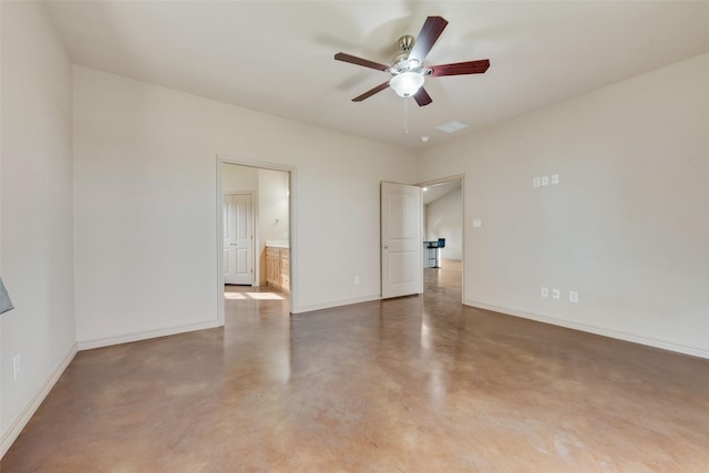 unfurnished room with ceiling fan and concrete flooring