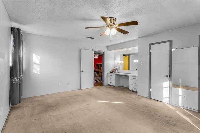 unfurnished bedroom featuring light carpet and a textured ceiling