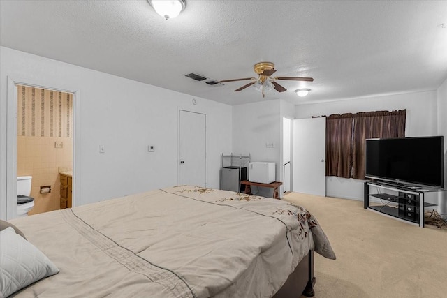 bedroom with a textured ceiling, ceiling fan, and light carpet