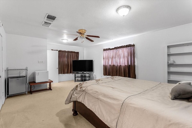 carpeted bedroom featuring a textured ceiling and ceiling fan