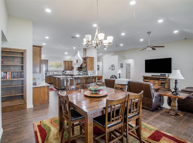 dining space featuring dark hardwood / wood-style floors and ceiling fan with notable chandelier