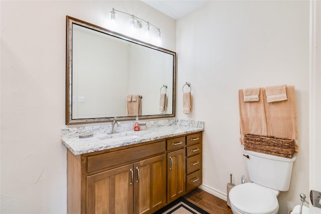 bathroom with hardwood / wood-style floors, vanity, and toilet