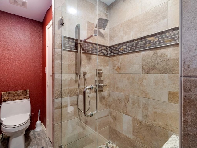 bathroom featuring an enclosed shower and toilet