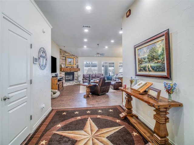 living room featuring ceiling fan, a fireplace, wood-type flooring, and lofted ceiling