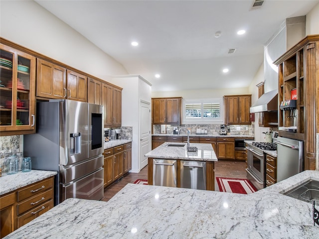 kitchen featuring light stone countertops, sink, stainless steel appliances, backsplash, and lofted ceiling