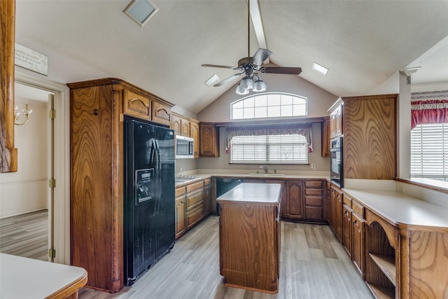 kitchen with a center island, light hardwood / wood-style flooring, black appliances, and sink