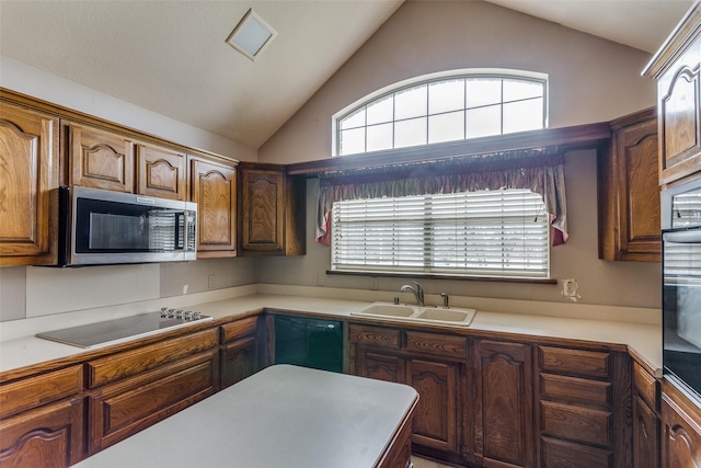 kitchen featuring black appliances, sink, and vaulted ceiling