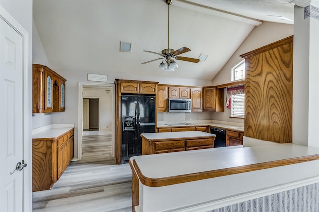 kitchen featuring kitchen peninsula, ceiling fan, black appliances, light hardwood / wood-style flooring, and lofted ceiling