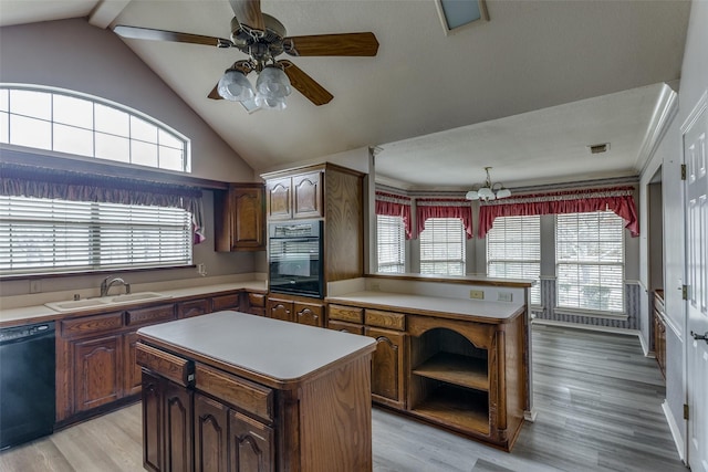 kitchen featuring a wealth of natural light, a center island, black appliances, and sink