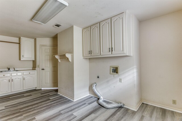 laundry area with cabinets, hookup for a washing machine, electric dryer hookup, sink, and light hardwood / wood-style flooring