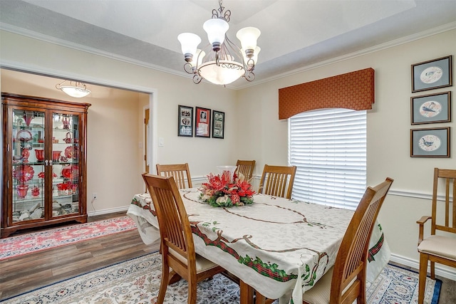 dining room featuring hardwood / wood-style flooring, crown molding, and a chandelier