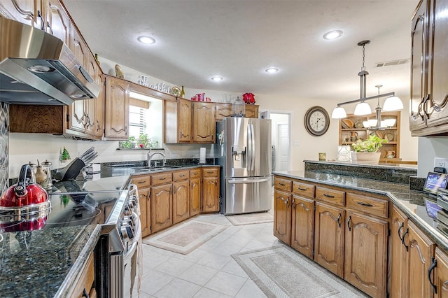 kitchen featuring dark stone counters, stainless steel appliances, sink, pendant lighting, and light tile patterned flooring