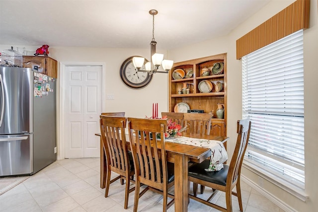 dining space with light tile patterned floors and a chandelier