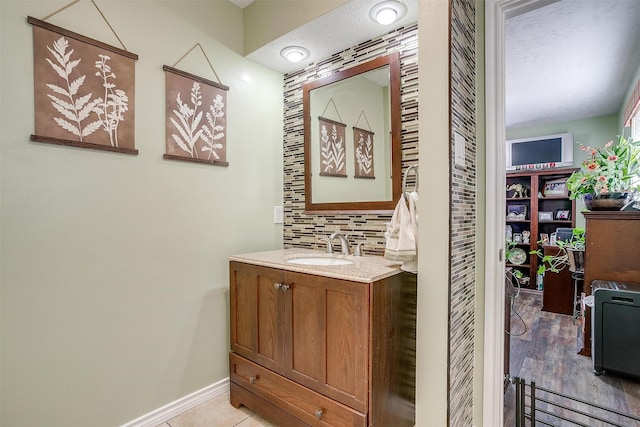 bathroom with vanity, hardwood / wood-style flooring, and backsplash