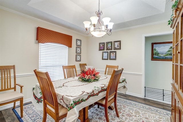 dining space with hardwood / wood-style floors, crown molding, and a chandelier