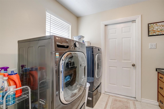 clothes washing area featuring light tile patterned floors and separate washer and dryer