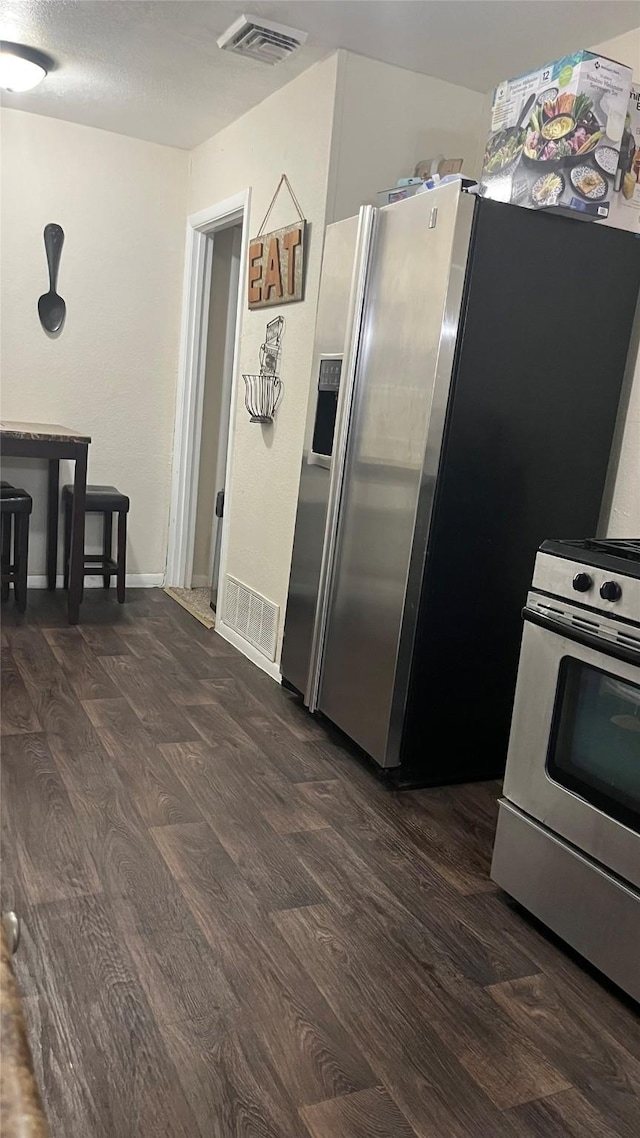 kitchen featuring stainless steel appliances and dark hardwood / wood-style floors