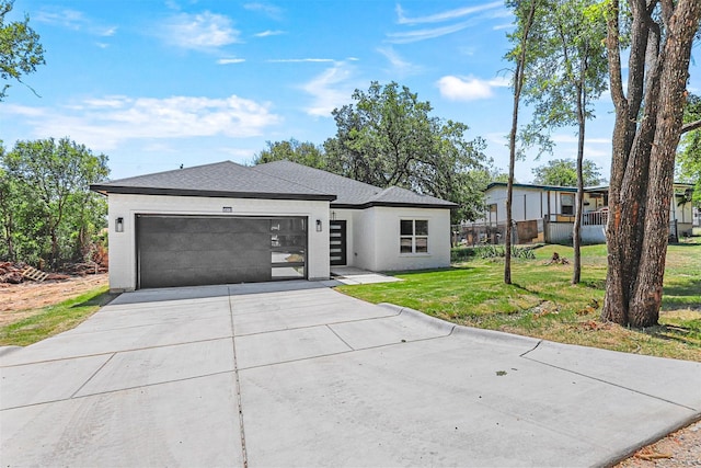 single story home with a garage and a front lawn