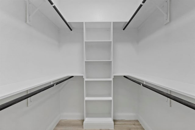 walk in closet with light hardwood / wood-style flooring