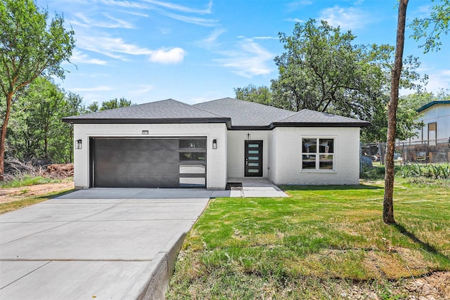 prairie-style home with a garage and a front lawn