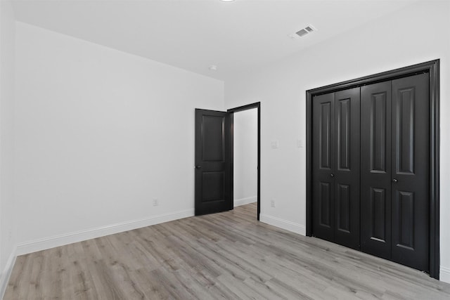 unfurnished bedroom with light hardwood / wood-style floors and a closet