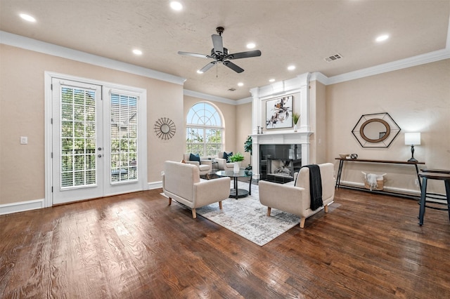 living room with a tiled fireplace, ceiling fan, dark hardwood / wood-style flooring, and ornamental molding