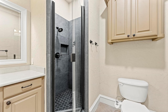 bathroom with a shower with door, vanity, and toilet