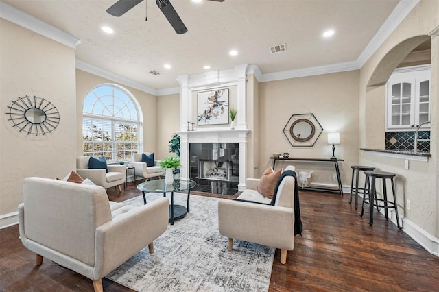 living room featuring ornamental molding, dark wood-type flooring, visible vents, and baseboards