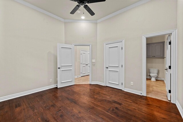 unfurnished bedroom featuring connected bathroom, ceiling fan, a high ceiling, crown molding, and hardwood / wood-style flooring