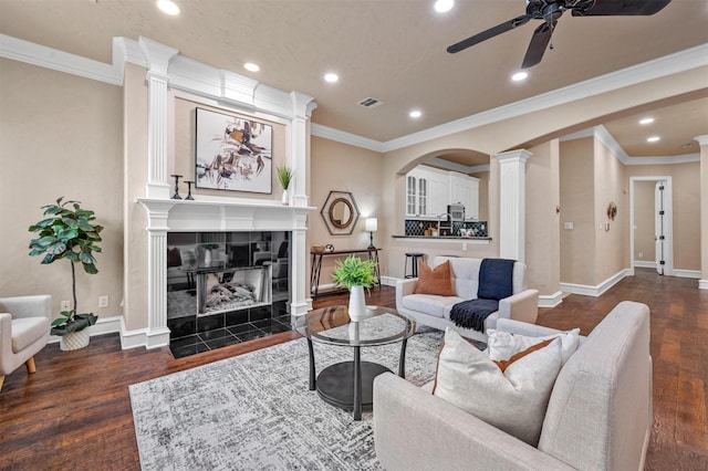 living room featuring dark hardwood / wood-style floors, ornamental molding, and a fireplace