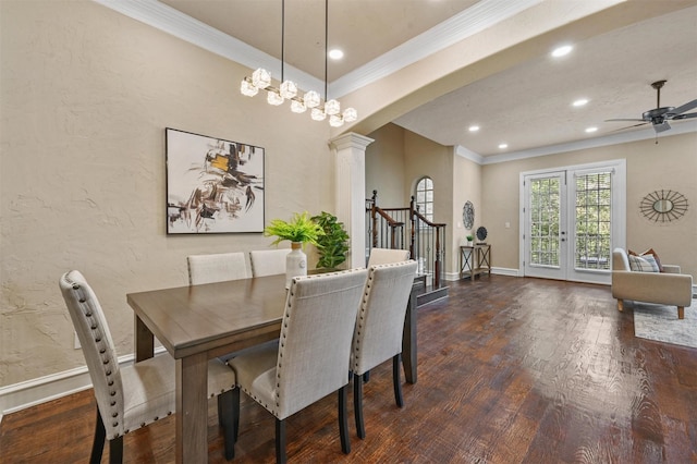 dining room with dark hardwood / wood-style floors, ornamental molding, ceiling fan with notable chandelier, and decorative columns