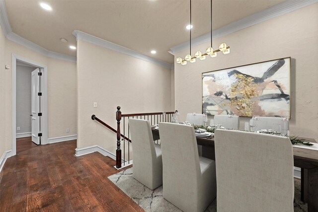 dining area with dark hardwood / wood-style flooring, crown molding, and an inviting chandelier