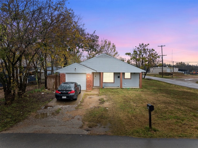 single story home featuring a lawn and a garage