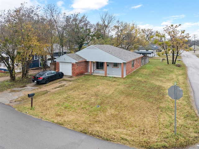 view of front of house featuring a porch, a front yard, and a garage