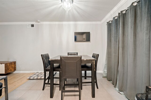 tiled dining area featuring a textured ceiling, a notable chandelier, and crown molding