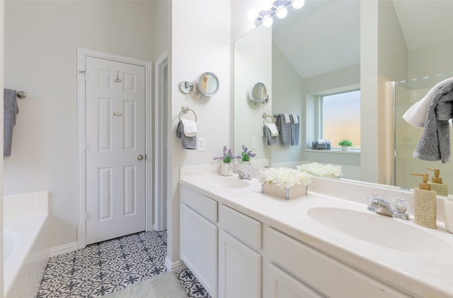 bathroom featuring tile patterned flooring, vanity, a tub, and vaulted ceiling