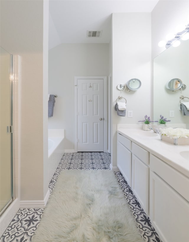 bathroom featuring tile patterned flooring, vanity, independent shower and bath, and vaulted ceiling