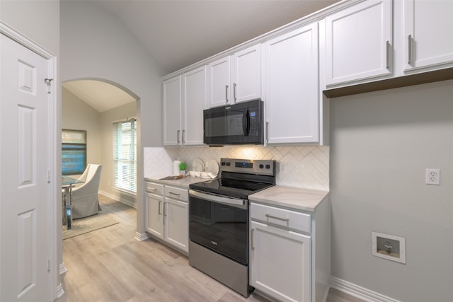 kitchen with backsplash, stainless steel electric stove, white cabinets, vaulted ceiling, and light hardwood / wood-style floors