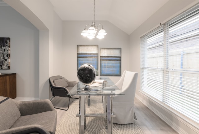 dining area featuring light hardwood / wood-style flooring, lofted ceiling, and an inviting chandelier