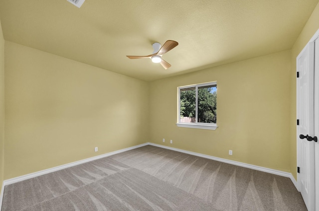 carpeted spare room featuring ceiling fan