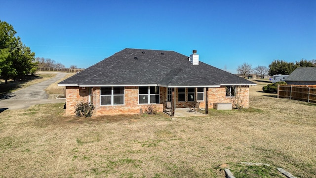 back of house with a lawn and a patio area