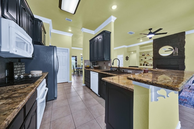 kitchen with white appliances, sink, crown molding, a kitchen bar, and kitchen peninsula