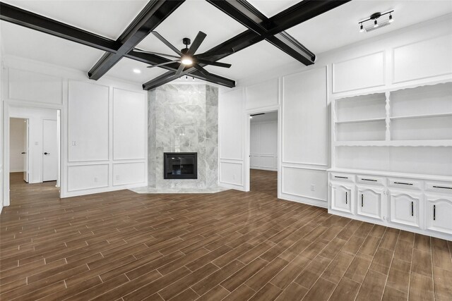 unfurnished living room featuring beamed ceiling, ceiling fan, dark wood-type flooring, and coffered ceiling