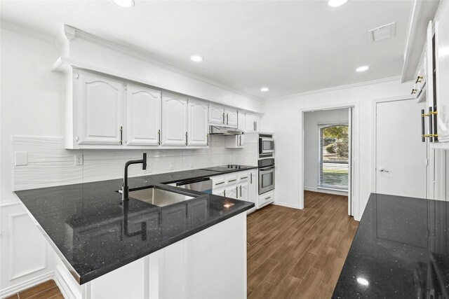 kitchen with kitchen peninsula, sink, white cabinetry, and stainless steel appliances