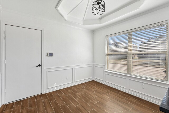 unfurnished room featuring dark hardwood / wood-style floors, a raised ceiling, and crown molding