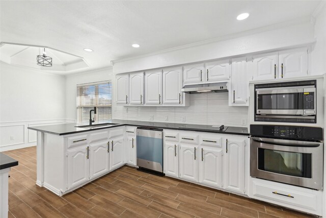 kitchen with stainless steel appliances, white cabinetry, dark wood-type flooring, and sink