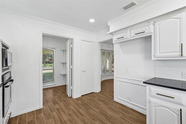 kitchen featuring plenty of natural light, white cabinets, dark wood-type flooring, and appliances with stainless steel finishes